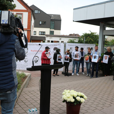 Bild vergrößern: Angehörige der Ermordeten vom 19. Februar erinnern mit Fotos an die Opfer.