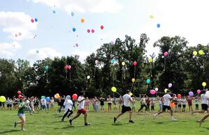 Bild vergrößern: Kinder und Betreuer*innen lassen Luftballons steigen