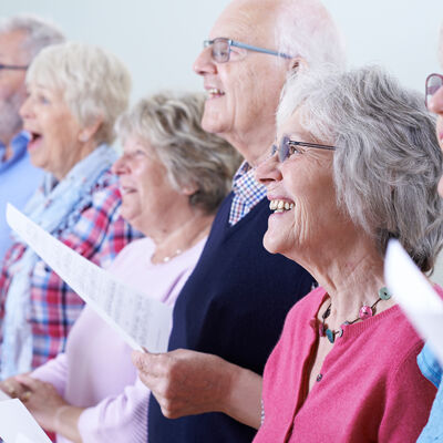 Bild vergrößern: Seniorinnen und Senioren singen gemeinsam und haben dabei viel Spaß.