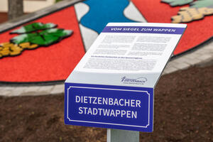 Bild vergrößern: Schild am Dietzenbacher Stadtwappen, auf dem die Entstehung des Wappens beschrieben ist und die Sponsoren genannt sind.