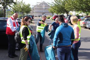 Bild vergrößern: Männer und Frauen bekommen Müllsäcke und Greifzangen in die Hand, um bei der Aktion "Sauberhaftes Dietzenbach" mitzumachen.