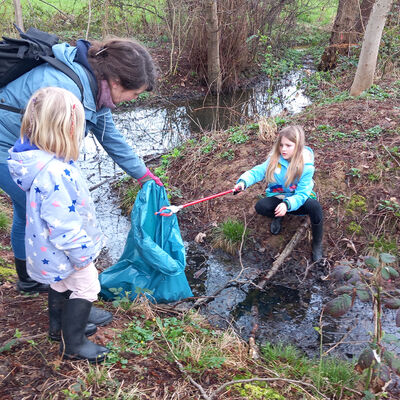 Bild vergr&ouml;&szlig;ern: Gro&szlig;e und kleine flei&szlig;ige Helfer: Im Hessentagspark war unter anderem eine Gruppe des ADFC mit S&auml;cken und Zangen unterwegs, zu der diese engagierte Mutter mit ihren zwei Kindern z&auml;hlte.