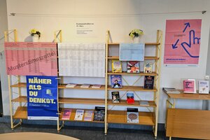 Bild vergr&ouml;&szlig;ern: Ein Holzregal, auf dem B&uuml;cher und Brosch&uuml;ren verteilt sind.