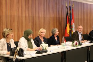 Bild vergr&ouml;&szlig;ern: Ein Mann und vier Frauen sitzen an einem Tisch im Konferenzsaal.