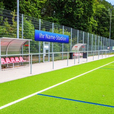 Bild vergr&ouml;&szlig;ern: Seitenansicht des Kunstrasenplatzes mit dem Schriftzug "Ihr Name-Stadion".