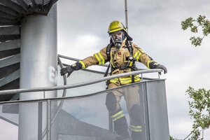 Bild vergr&ouml;&szlig;ern: Ein Mitglied der Freiwilligen Feuerwehr in Einsatzkleidung und Sauerstoffflasche auf dem R&uuml;cken.