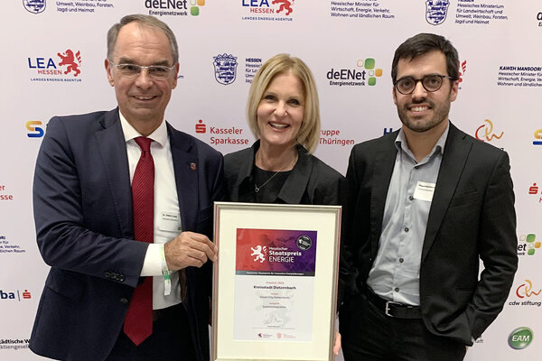 Verleihung des &raquo;Hessischen Staatspreis f&uuml;r innovative Energiel&ouml;sungen 2026&laquo; f&uuml;r die Kreisstadt Dietzenbach: B&uuml;rgermeister Dr. Dieter Lang, Monika R&uuml;hr (Fachbereichsleiterin Bau- & Immobilienmanagement), Miguel Mart&iacute;nez S&aacute;nchez (Abteilungsleiter Immobilienmanagement).