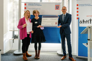 Bild vergrößern: Kirsten Wolf und Kathrin Lyrhammer (von links) empfangen den Preis aus den Händen von Minister Kai Klose.